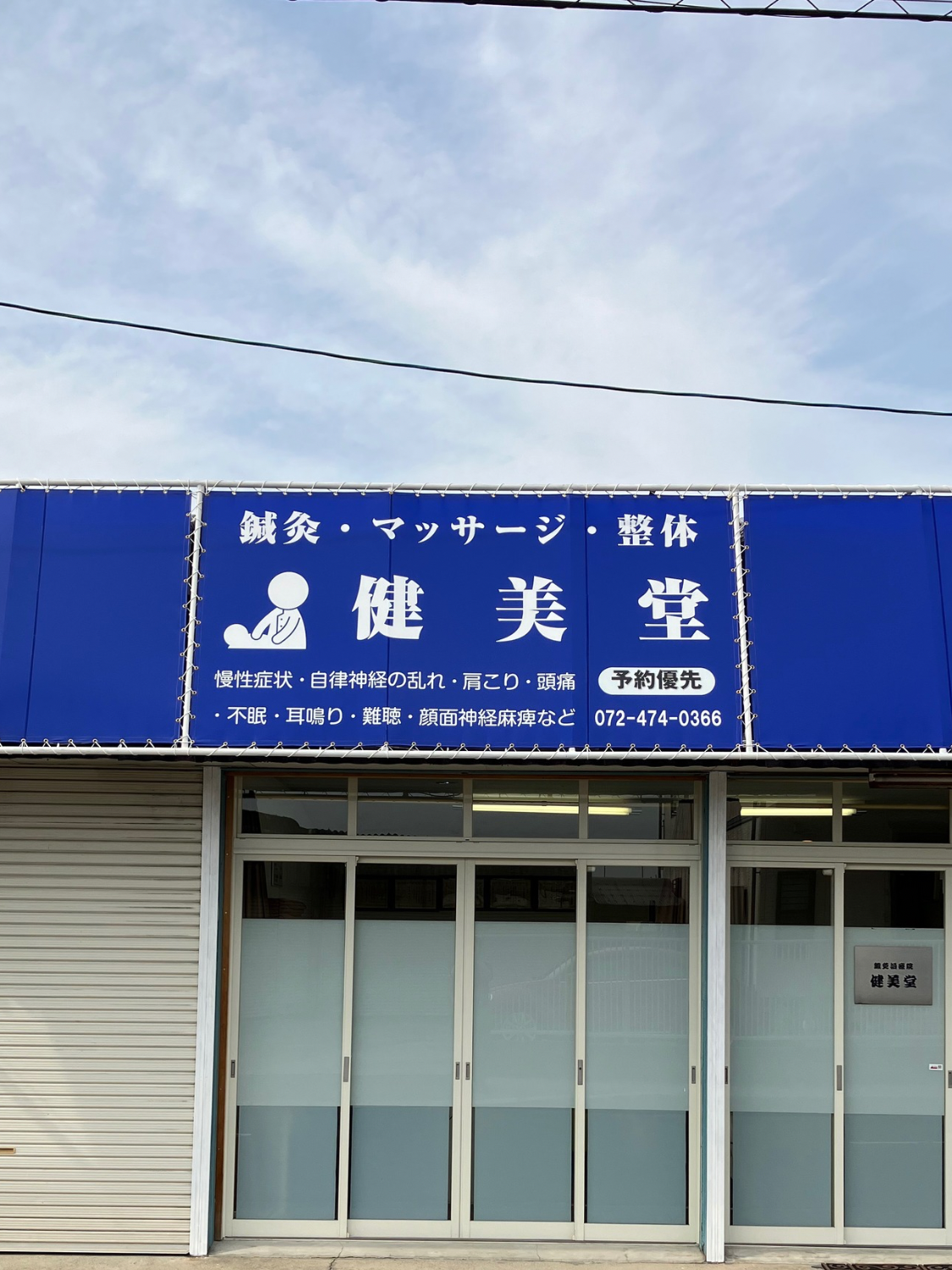 鍼灸治療院 健美堂の外観（青い看板が目印）